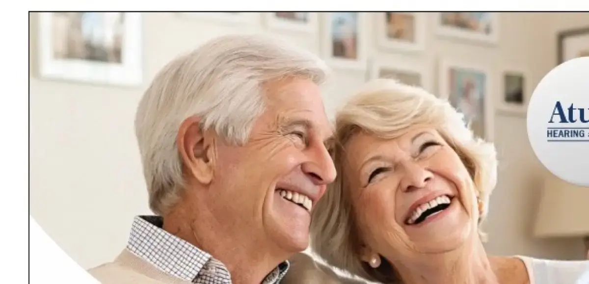 Happy elderly couple laughing together after hearing aid fitting at Atulya Hearing